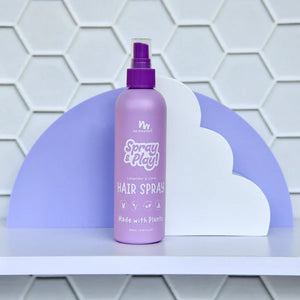 Purple hair spray bottle with a purple cap on a white shelf against a geometric-patterned wall.