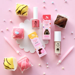 Kids makeup products with birthday cake theme on a pink background