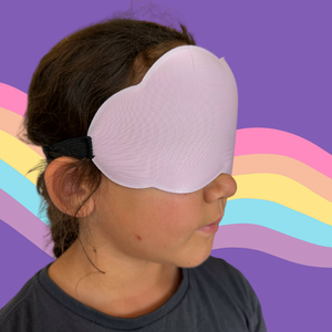Little Girl wearing a light purple sleep mask against a colorful abstract background