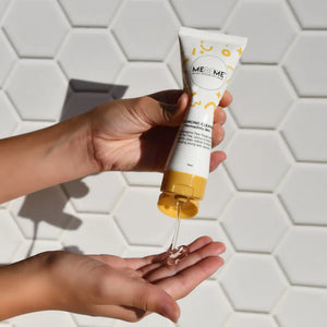 Hand holding a MEBEME skincare product with a hexagonal tile background