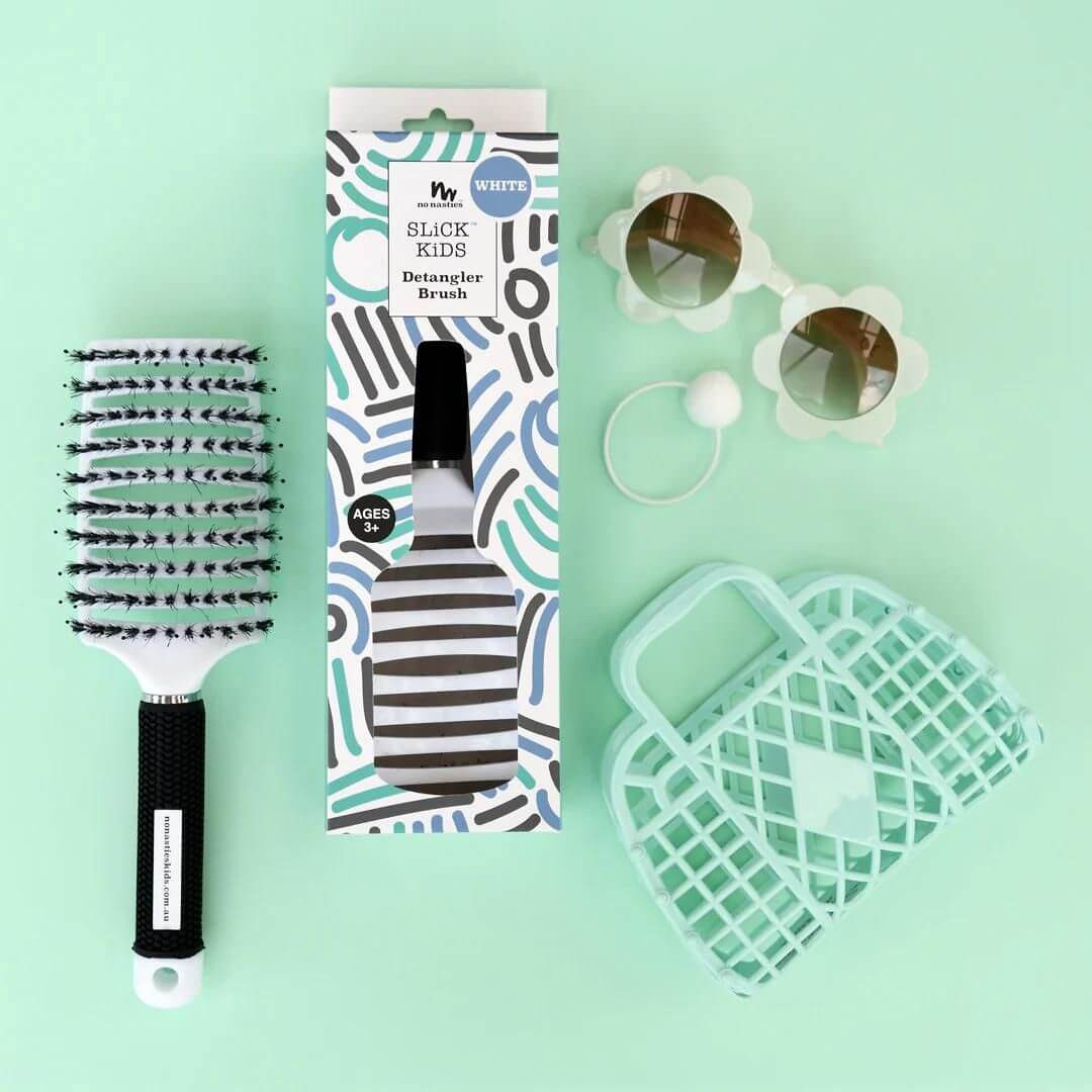 white-detangler-brush-on-green-background