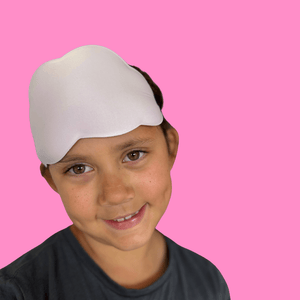 Child wearing a cloud sleep mask against a pink background