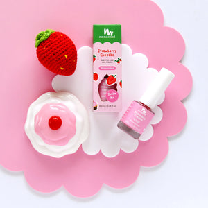 Strawberry scented kids nail polish and strawberry shaped item on a pink flower shaped background.