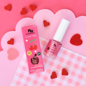 hot pink kids nail polish on pink and white chequered background with red hearts