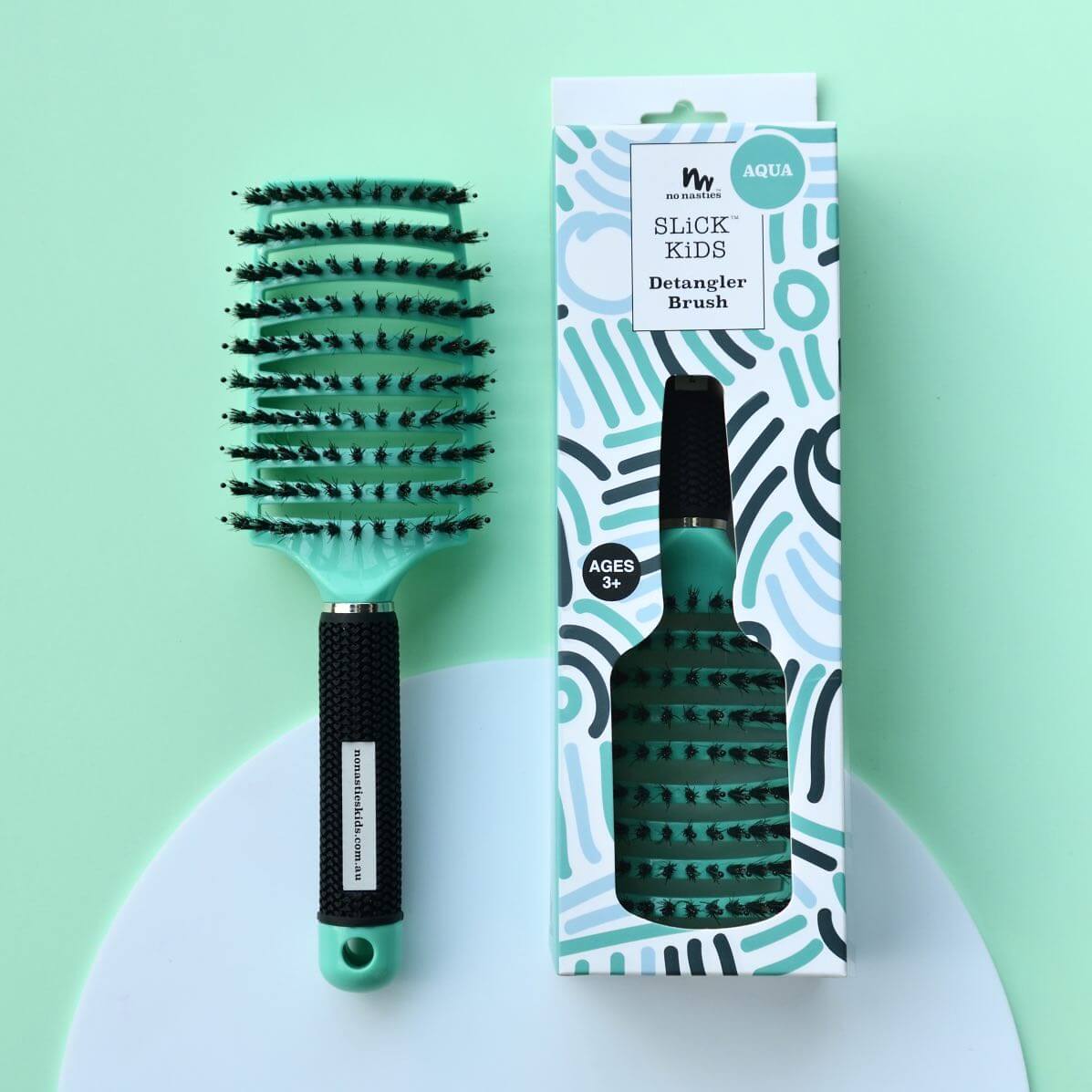 Two bottles of 'Knot Chance' hair detangler with a comb and brush on a white tiled background.