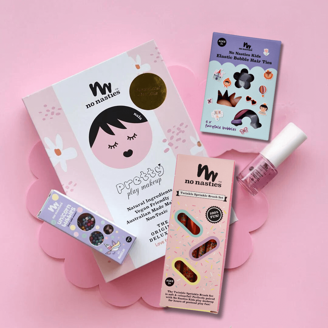 pink kids makeup set with accessories on pink background