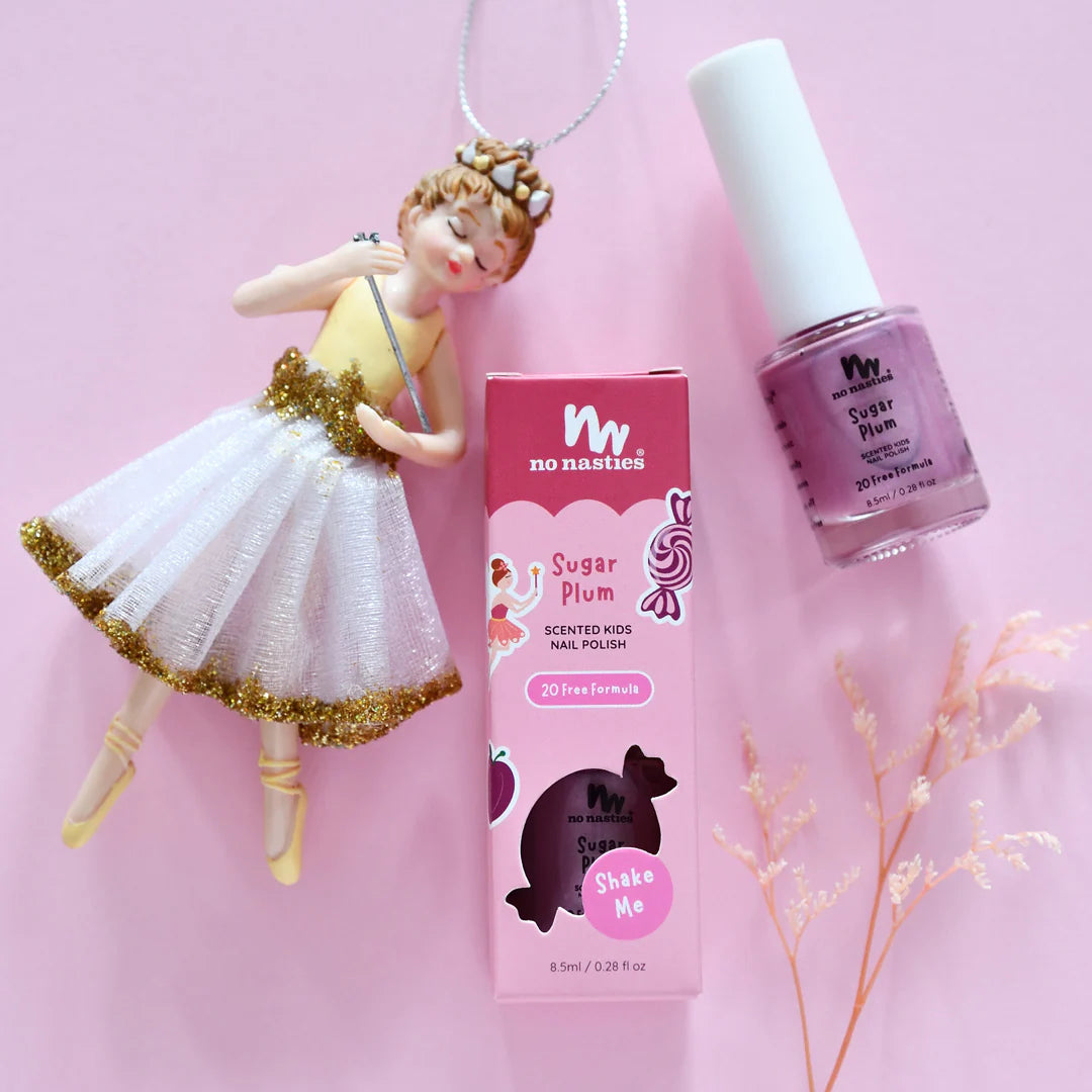No Nasties Sugar Plum scented kids&#39; nail polish with packaging and a doll on a pink background