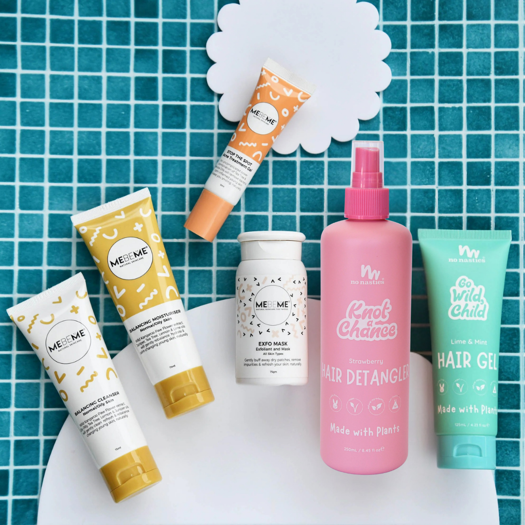 Collection of hair care products and teen skincare on a blue tiled background