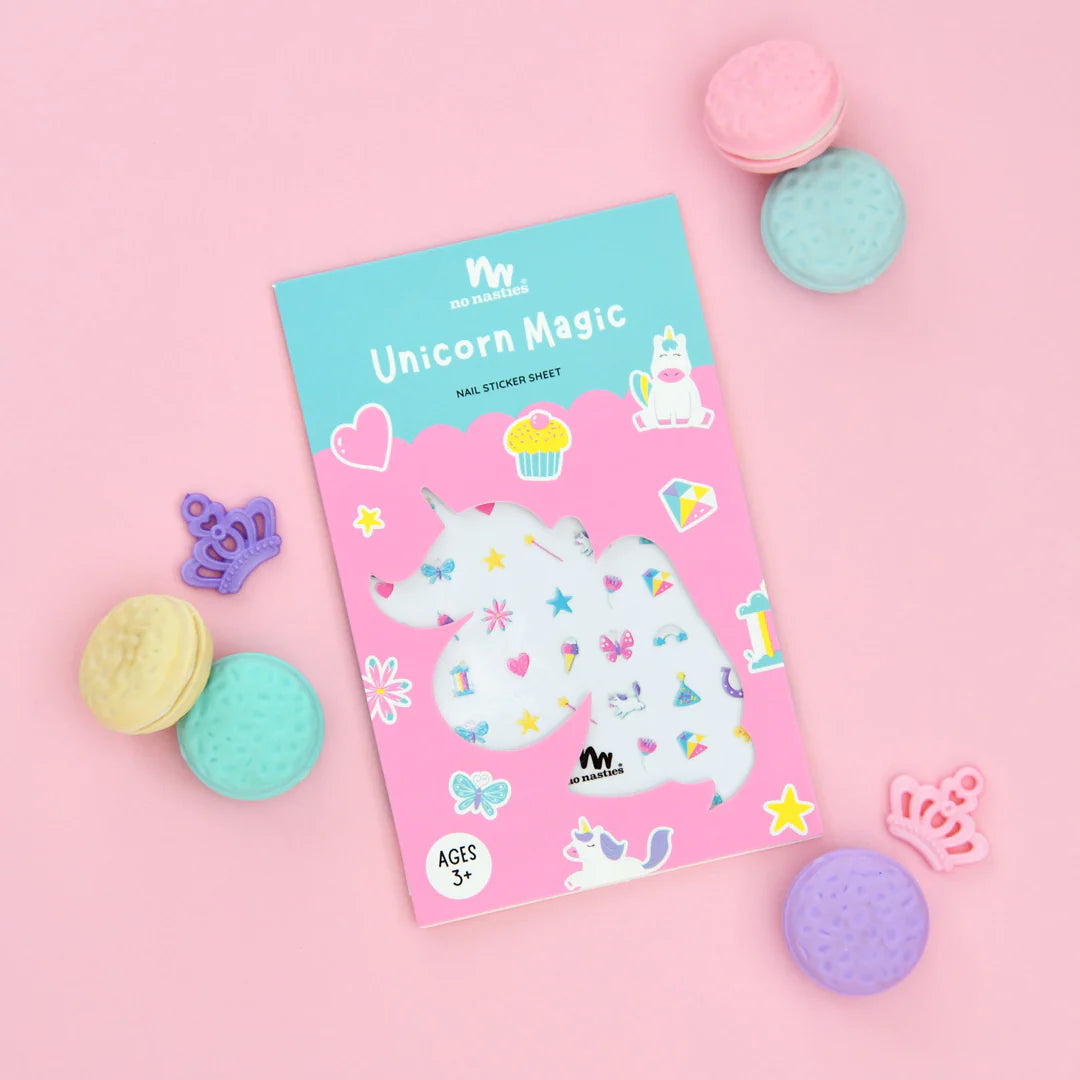 Unicorn nail stickers on pink back ground with pretend macaroons