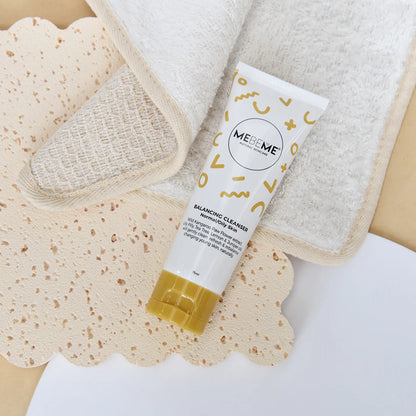 Tube of MEBEME balancing cleanser on a textured surface with a towel in the background