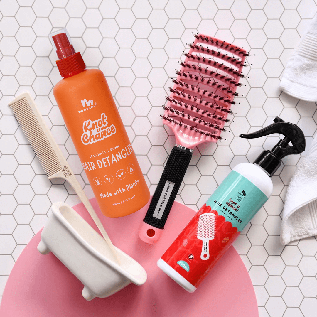 Hair care products including a bottle, brush, and comb on a tiled surface.