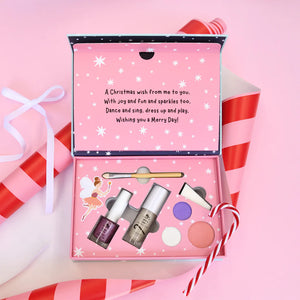 Kids makeup set with nail polish and lip products in a decorative box on a pink background