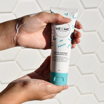 Hand holding a tube of MEBEME Gentle Cleanser against a tiled bathroom background