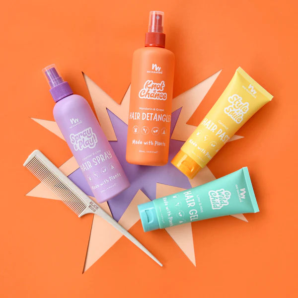Colorful No Nasties NZ hair care products including sprays, gel, and a comb on a pink background