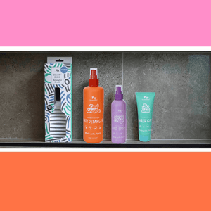 Set of hair care products including a box, spray bottle, and gel on a gray surface with an orange background.