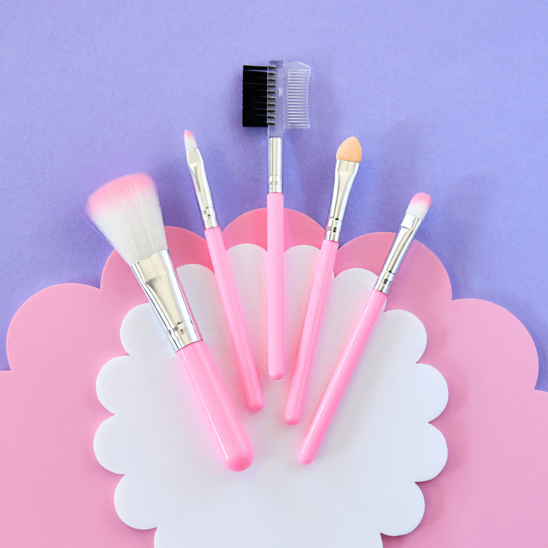 Set of pink makeup brushes on a decorative pink and white flower-shaped stand against a purple background