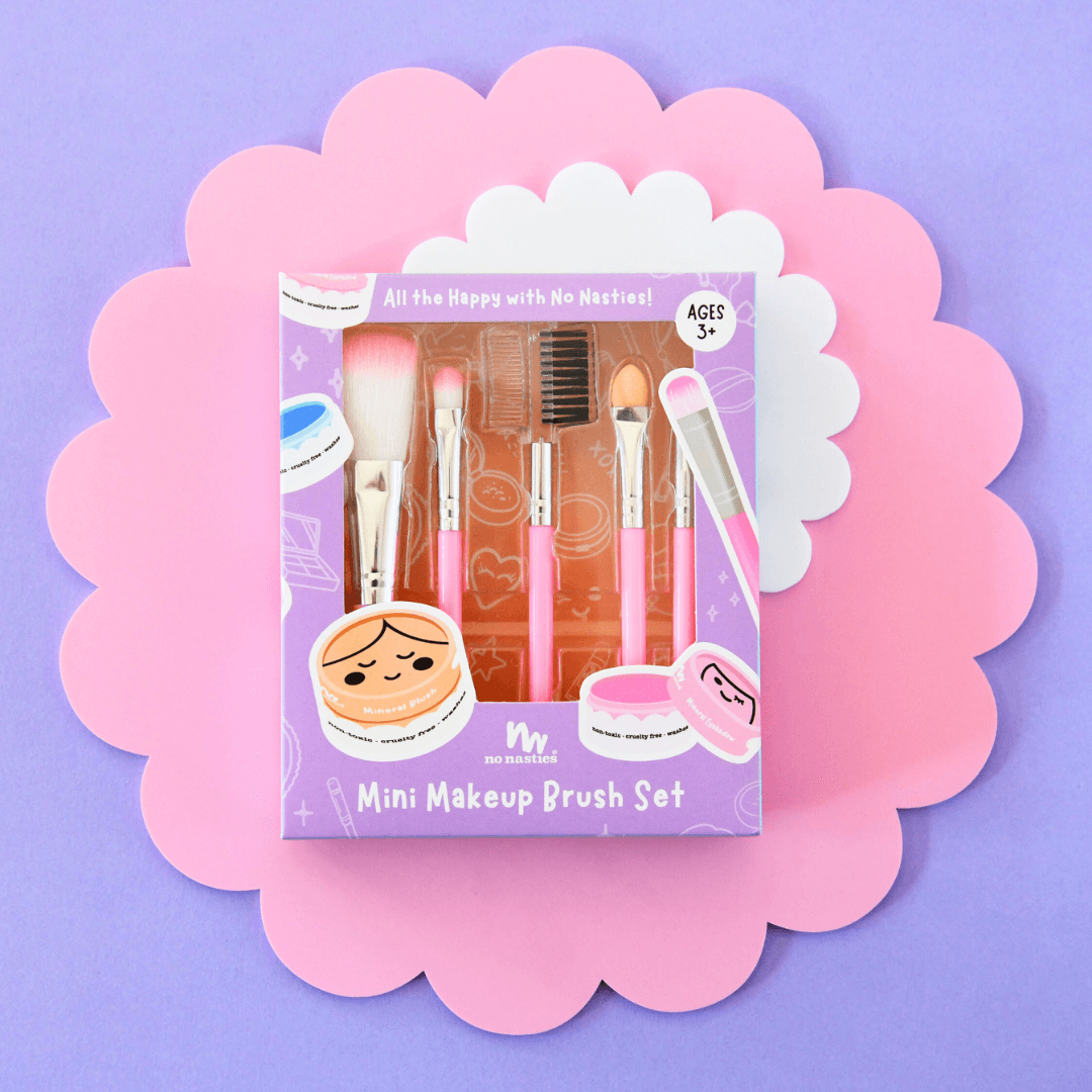 Mini makeup brush set packaging on a decorative pink and white background