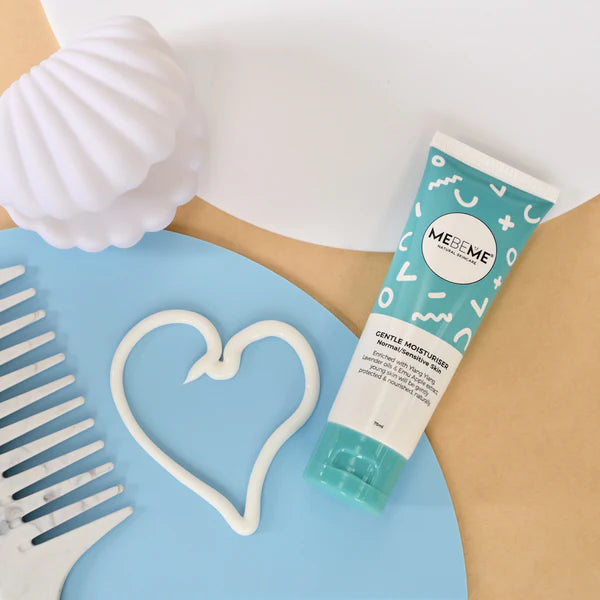 Tube of MEBEME skincare product on a blue surface with the moisturiser in a heart shape and comb.