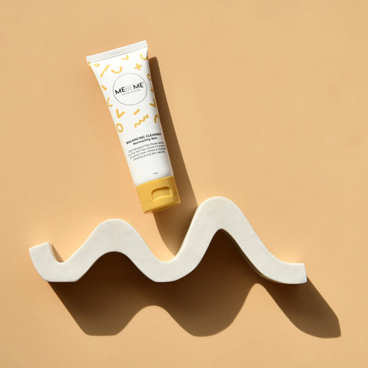 Tube of ME&ME skincare product on a wavy white stand against a beige background