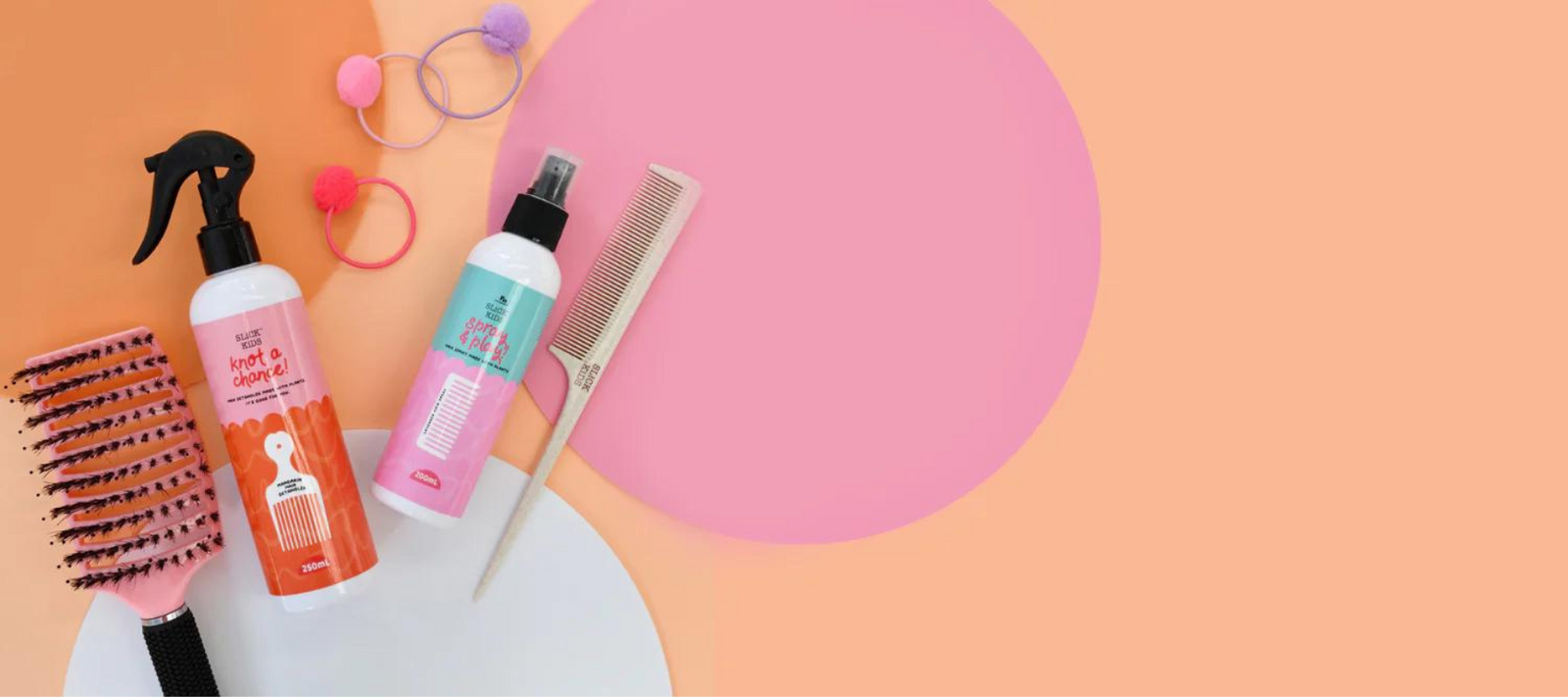 Natural detangling spray with detangler brush and alcohol free hair spray on colourful background