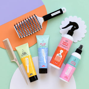 Natural hair styling products with brush and comb on bright coloured background