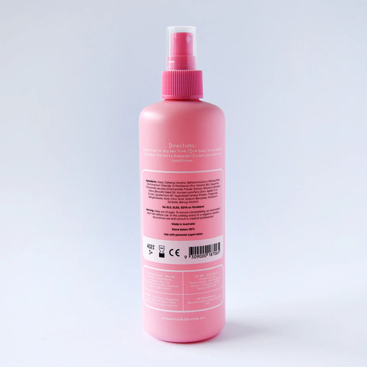Pink spray bottle with a label on a light gray background