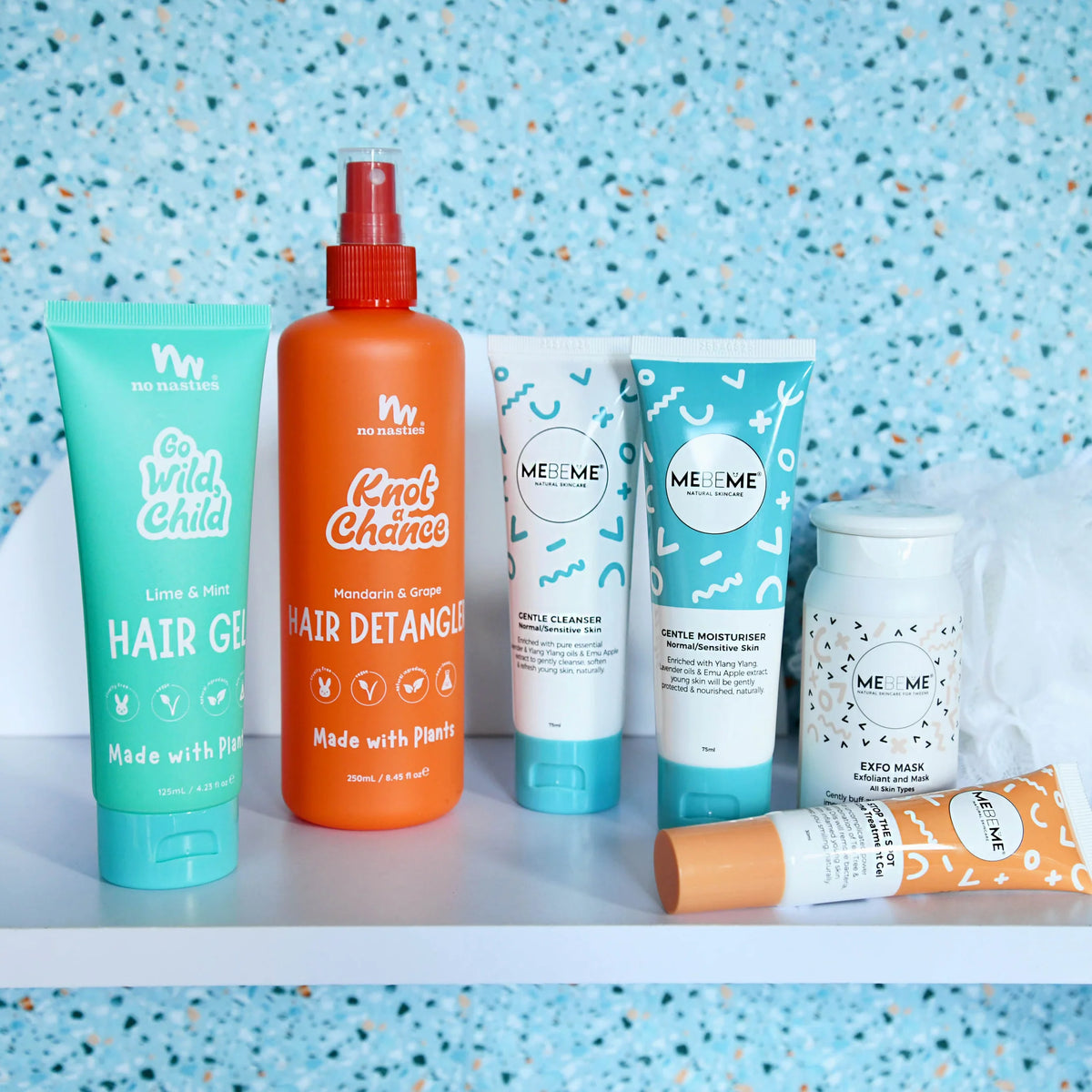 Collection of MEBEME Skincare and No Nasties hair care products on a shelf with a blue speckled background