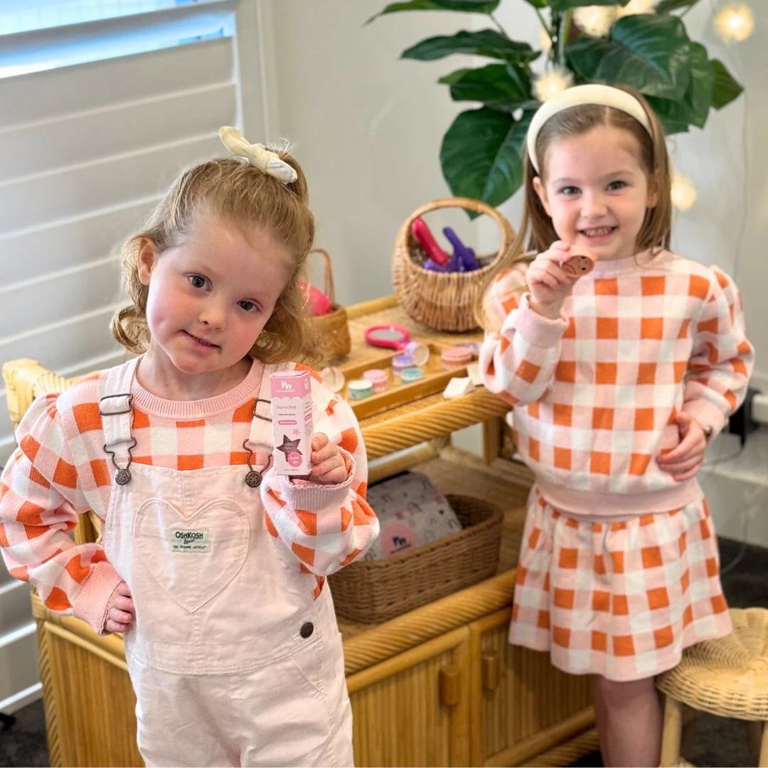 little girls holding pink nail polish and eco blush
