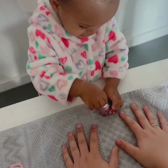 Little girl painting pink nails