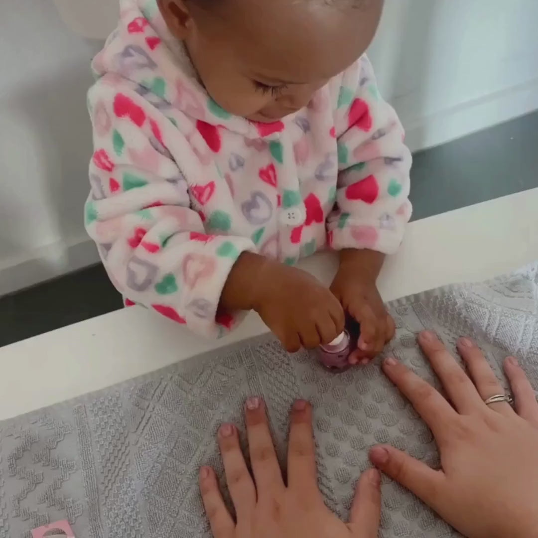 Little girl painting pink nails