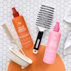 Two hair detangling products with tools on a tiled surface