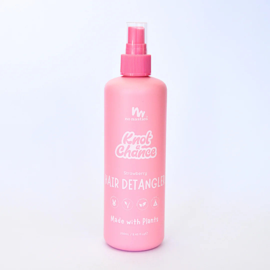 Pink hair detangler bottle with spray nozzle on a light purple background