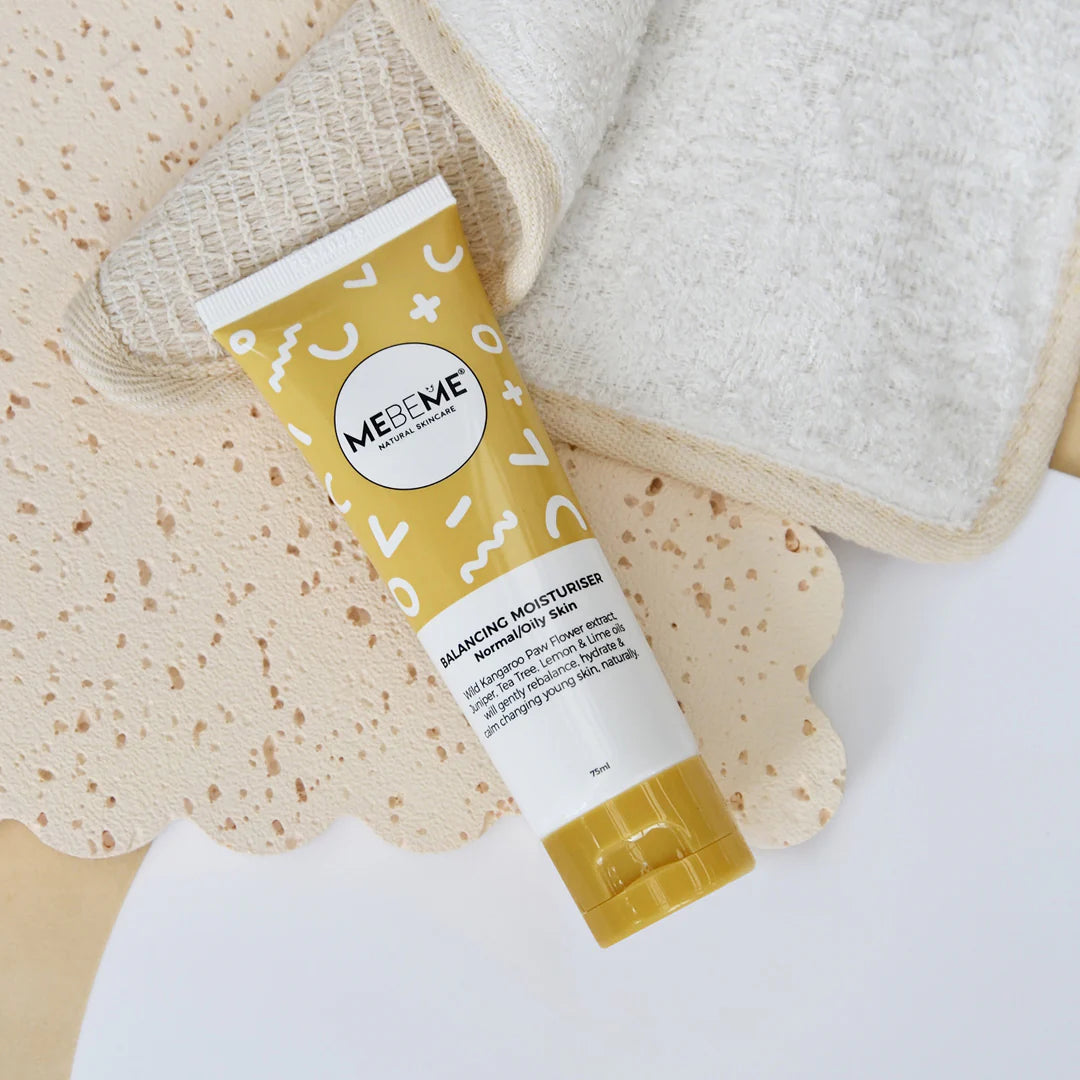 Tube of MEBEME Balancing Moisturiser with a textured towel and washcloth on a white background