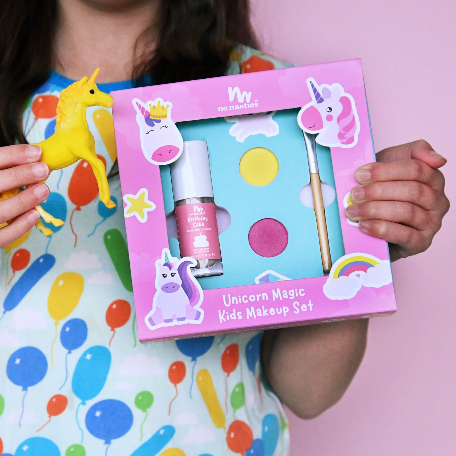 Unicorn-themed kids makeup set with accessories on a colorful background