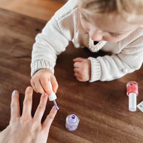purple kids nail polish on purple and white back ground with little grape buttons