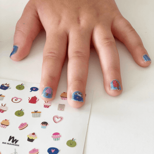 nail-stickers-with-blue-nail-polish-on-little-girls-hand