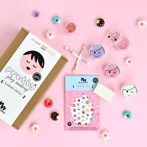 Pink kids play makeup set laid out on pink background